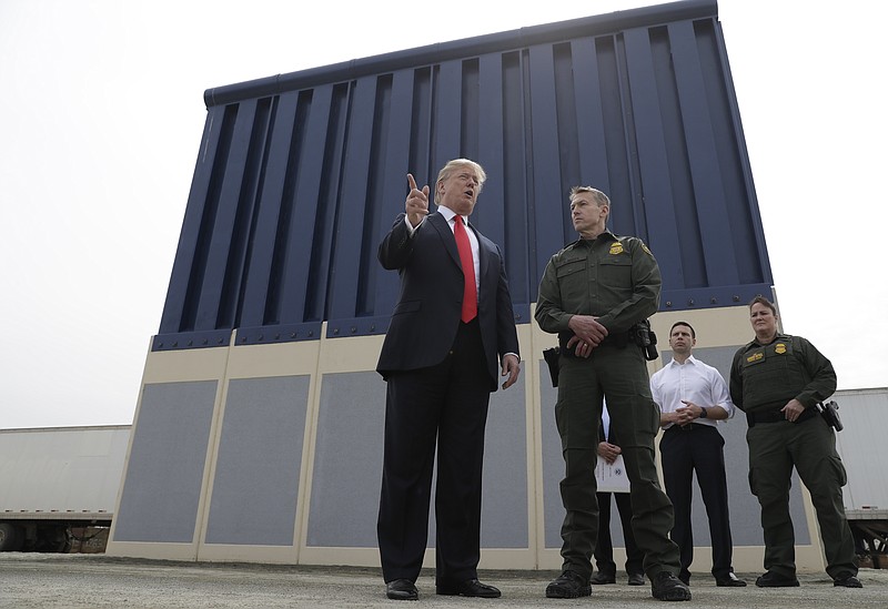 FILE - In this March 13, 2018, file photo, President Donald Trump speaks during as he reviews border wall prototypes, in San Diego, as Rodney Scott, the Border Patrol's San Diego sector chief, listens. Congress is heading toward a post-election showdown over President Donald Trump’s border wall, as GOP leaders signal they’re willing to engage in hardball tactics that could spark a partial government shutdown and the president revs up midterm crowds for the wall, a centerpiece of his 2016 campaign and a top White House priority. (AP Photo/Evan Vucci, File)