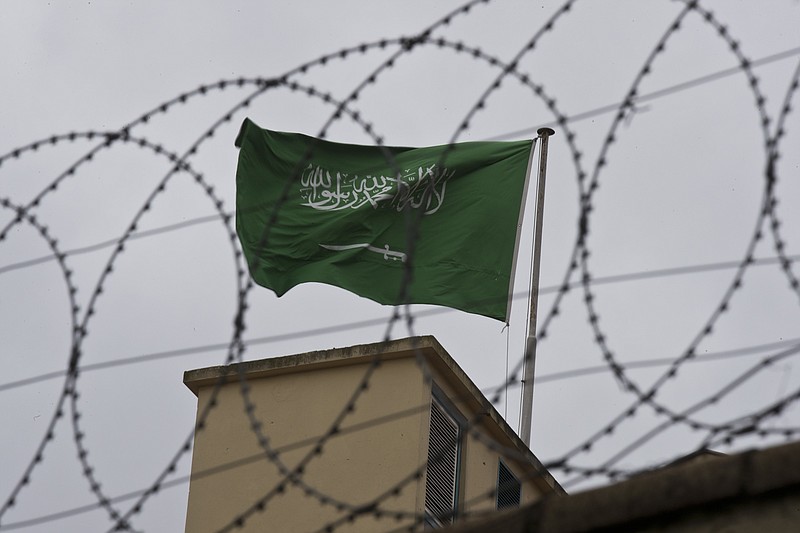 A flag of Saudi Arabia flies behind barb wire, on the roof top of Saudi Arabia's consulate in Istanbul, Saturday, Oct. 13, 2018.  Turkish officials have an audio recording of the alleged killing of journalist Jamal Khashoggi from the Apple Watch he wore when he walked into the Saudi Consulate in Istanbul over a week ago, a pro-government Turkish newspaper reported Saturday. (AP Photo/Petros Giannakouris)
