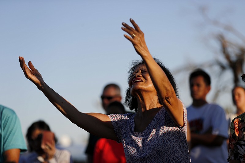 Letty Cervantes prays during Mass which was moved outdoors due to damage to Saint Dominic Catholic Church from Hurricane Michael in Panama City, Fla., Saturday, Oct. 13, 2018. (AP Photo/David Goldman)