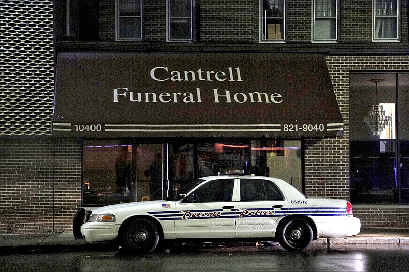 A Detroit Police vehicle is parked outside the Cantrell Funeral Home in Detroit on Friday, Oct. 12, 2018. Police said an anonymously written letter led inspectors to find the decomposed remains of 11 infants hidden in a ceiling compartment of the shuttered funeral home. (Junfu Han/Detroit Free Press via AP)
