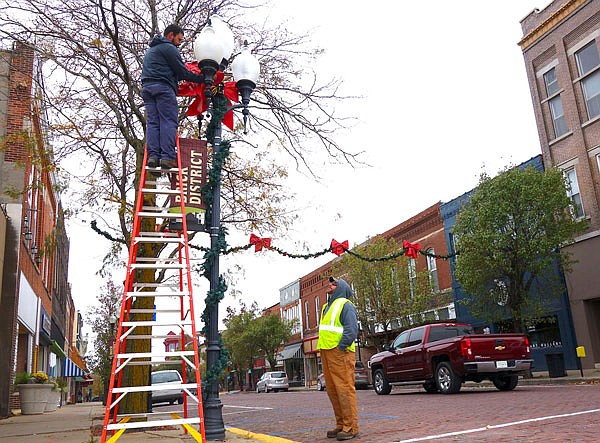 Fulton city workers put up holiday decor on Court Street last fall. A big kick off the the holiday season will be Nov. 2-3 in the Brick District.