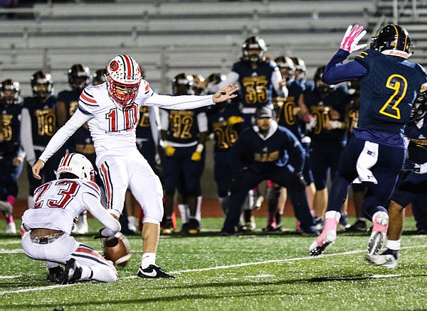 Ben Folz kicks a game-winning 35-yard field goal as Christian White holds during Friday night's game against Battle in Columbia.