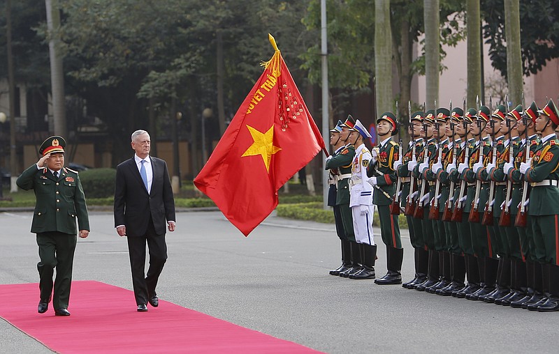 FILE - In this Jan. 25, 2018, file photo, U.S. Defense Secretary Jim Mattis and his Vietnamese counterpart Ngo Xuan Lich, left, review an honor guard in Hanoi, Vietnam. By making a rare second trip this year to Vietnam, Mattis is showing how intensively the Trump administration is trying to counter China’s military assertiveness by cozying up to smaller nations in the region who share American wariness about Chinese intentions. The visit beginning Tuesday also shows how far U.S.-Vietnamese relations have advanced since the tumultuous years of the Vietnam War, whose legacy includes a continued search for the remains of U.S. war dead on Vietnamese soil. (AP Photo/Tran Van Minh, File)