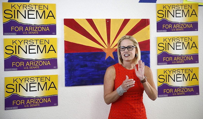 FILE - In this Aug. 28, 2018, file photo, Rep. Kyrsten Sinema, D-Ariz., talks to campaign volunteers at a Democratic campaign office in Phoenix. As the November elections near, Democrats are focusing on health care. It's been a constant drumbeat since the GOP launched its effort to repeal the Obama-era health law and is the subject of the greatest share of political ads on television now. It's a top issue in campaigns from Virginia to Nebraska to California, and especially in Arizona, where Democratic Rep. Kyrsten Sinema has made it the foundation of her Senate campaign. (AP Photo/Ross D. Franklin, File)