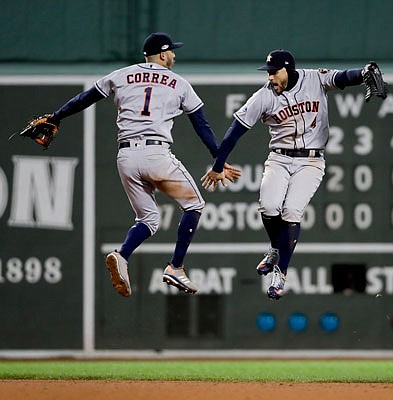 Astros center fielder George Springer (right) and shortstop Carlos Correa celebrate Saturday night's win against the Red Sox in Game 1 of the American League Championship Series in Boston.