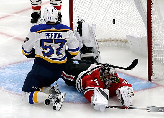 David Perron of the Blues scores againstBlackhawks goalie Cam Ward during the third period of Saturday night's game in Chicago.