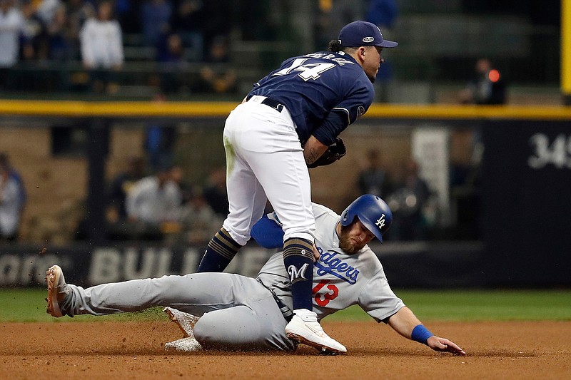 Milwaukee Brewers third baseman Hernan Perez (14) tags Los Angeles Dodgers' Max Muncy (13) out and turns to a double play during the eighth inning of Game 2 of the National League Championship Series baseball game Saturday, Oct. 13, 2018, in Milwaukee. (AP Photo/Jeff Roberson)