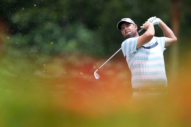 Marc Leishman of Australia follows his shot on the eighth hole during the third round of the CIMB Classic golf tournament at Tournament Players Club (TPC) in Kuala Lumpur, Malaysia, Saturday, Oct. 13, 2018. (AP Photo/Yam G-Jun)