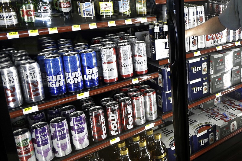 FILE - This Wednesday, April 19, 2017 file photo shows the beer cooler behind the counter in a convenience store in Sheridan, Ind. In future sweltering years with a double whammy of heat and drought, losses of barley yield can be as much as 17 percent, computer simulations show. And that means “beer prices would, on average, double,” even adjusting for inflation, said a study published in the journal Nature Plants on Wednesday, Oct. 17, 2018. (AP Photo/Michael Conroy)