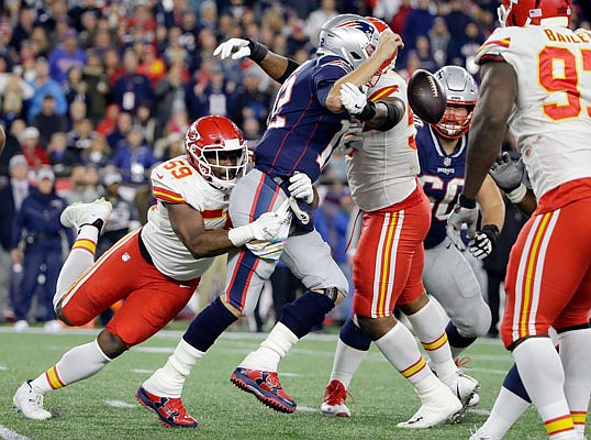 Patriots quarterback Tom Brady fumbles the ball as Chiefs linebacker Reggie Ragland wraps him up during the second half of Sunday night's game in Foxborough, Mass.