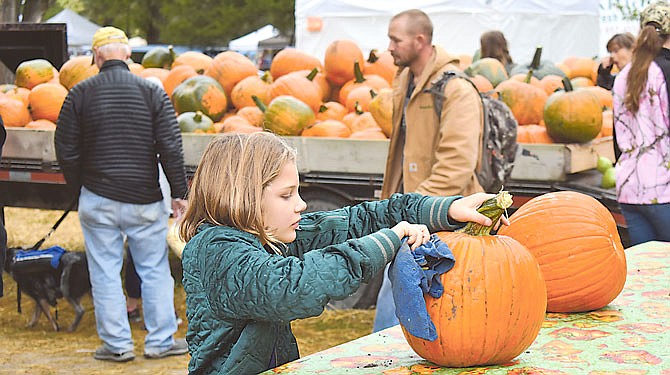 Abbey Christianson, 7, cleans off a pumpkin from Hackman Farms before taking it home Sunday at the 27th annual Hartsburg Pumpkin Festival. 