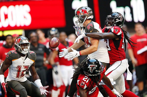 Buccaneers tight end Cameron Brate (84) bobbles the ball while trying to make a catch against the defense of Falcons linebacker De'Vondre Campbell during the second half of Sunday's' game in Atlanta. The ball was caught by Buccaneers wide receiver Chris Godwin (12).