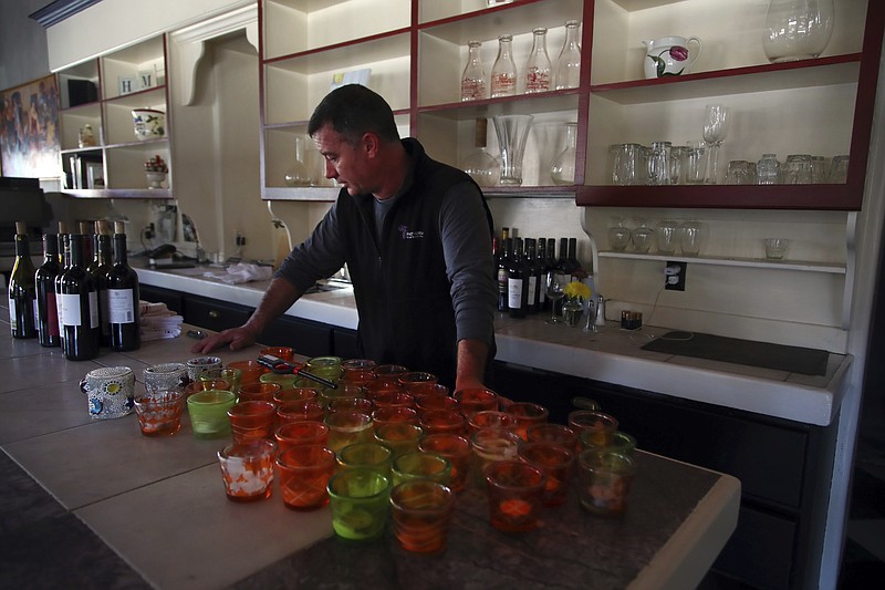 All Seasons restaurant chef Kevin Kathman stands at the bar Monday, Oct. 15, 2018, in Calistoga, Calif. The restaurant was forced to close, losing an estimated $20,000 per day, as their power was cut off. Northern California's biggest utility has taken the unprecedented step of cutting electricity for tens of thousands of customers in an attempt to prevent wildfires amid rising winds and official warnings on Monday of extreme fire danger. (AP Photo/Ben Margot)