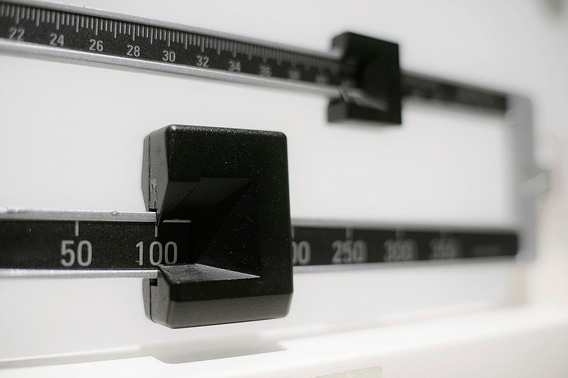 This April 3, 2018 file photo shows a closeup of a beam scale in New York. New research, published Tuesday, Oct. 16 in the Journal of the American Medical Association, suggests obesity surgery may dramatically lower the danger of heart attacks and strokes in people with diabetes. The study reinforces evidence that the benefits of stomach-shrinking surgery extend beyond weight loss.  (AP Photo/Patrick Sison, File)