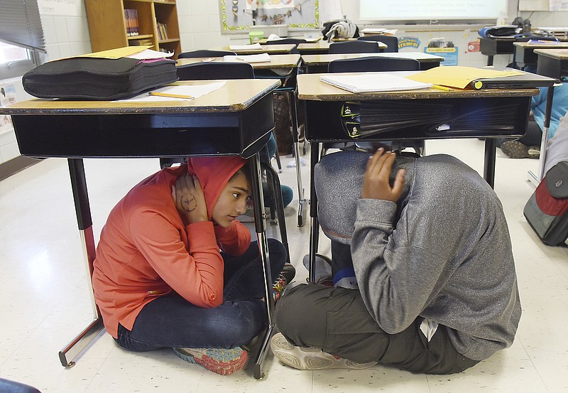 Julie Smith/News Tribune
Aquilla Hayes, left, and Keyair Hunt, both sixth grade students in Jody Thomas' class, crawled under desks as they, faculty and staff of Thomas Jefferson Middle School participated in Thursday's earthquake drill. 