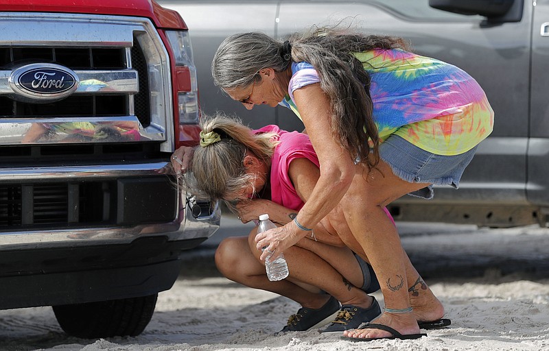 Nancy Register weeps as she is comforted by Roxie Cline, right, after she lost her home and all the contents inside to Hurricane Michael in Mexico Beach, Fla., Wednesday, Oct. 17, 2018. Register said she doesn't know how she and her husband will make it through this, saying they only have money to last them four more days. (AP Photo/Gerald Herbert)