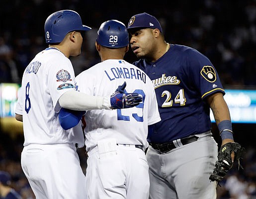 Jesus Aguilar of the Brewers and Manny Machado of the Dodgers have words after a play at first base during the 10th inning of Tuesday night's Game 4 of the National League Championship Series in Los Angeles.