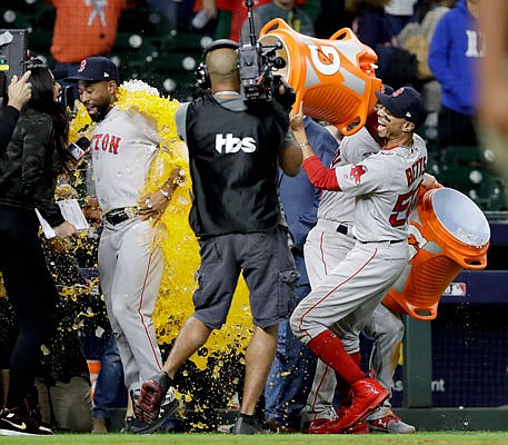 Jackie Bradley Jr. gets a sports drink dumped on him by Red Sox teammate Mookie Betts after Tuesday's 8-2 win against the Astros in Game 3 of the American League Championship Series in Houston.