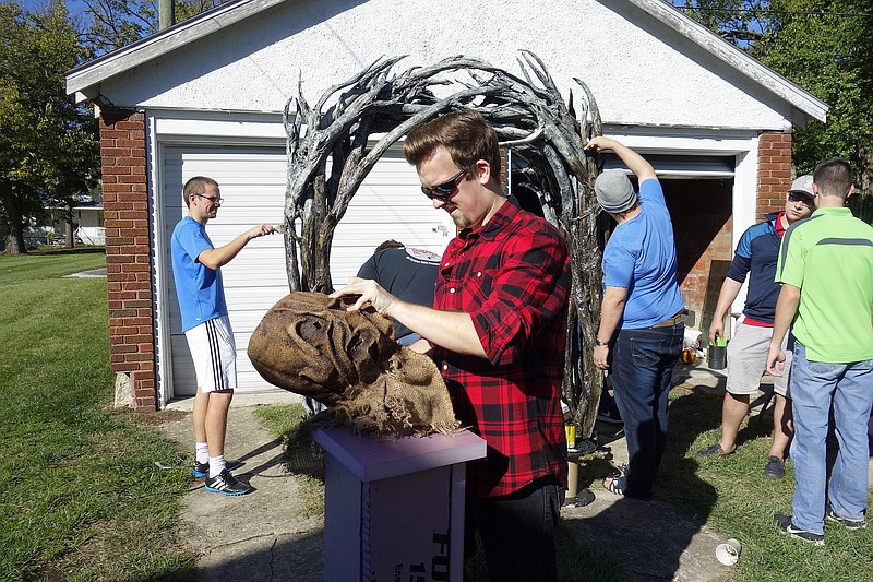 <p>Jenny Gray/FULTON SUN</p><p>Eric Woytus adjusts a burlap mask over a Styrofoam head form while his Phi Delta Theta brothers work on other spooky projects. They are preparing for their fund-raiser Field of Screams event to be 8:30-10:30 p.m. Nov. 3 at the fraternity house.</p>