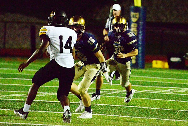 Alex Clement of Helias looks for running room behind the blocking of teammate Andrew Bexten during a game against Monroe City earlier this month at Ray Hentges Stadium.