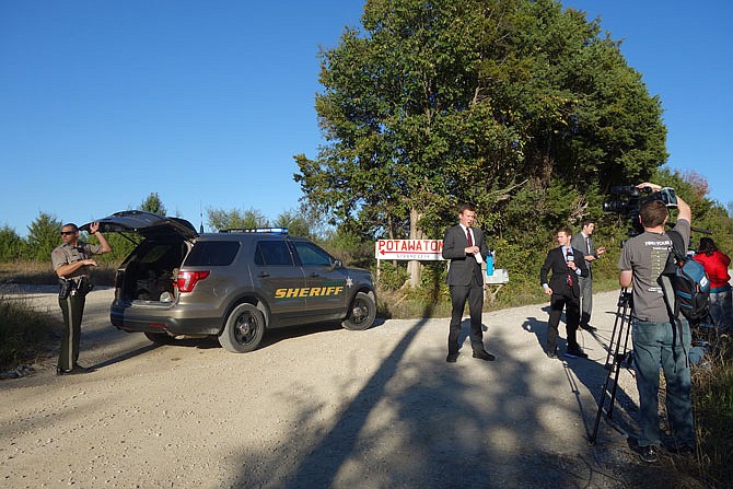 Members of the media prepare for a 5 p.m. news broadcast just outside Potawatomi Campground, an area east of Fulton where a helicopter crashed Wednesday afternoon.