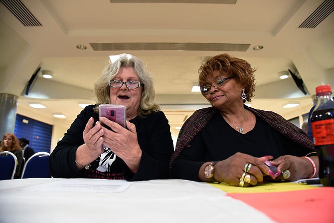 Joyce Harkins, left, and Freda McKee turn off an alarm that was set for timekeeping Thursday at a candidate forum at Lincoln University. The pair volunteered to keep time at the forum, which featured candidates for the state Legislature as well as Cole County.