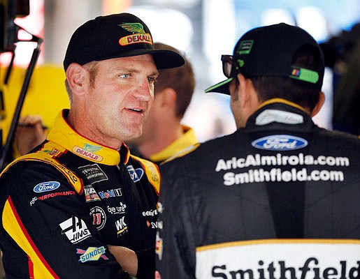 Clint Bowyer talks with Aric Almirola before practice Friday at Kansas Speedway in Kansas City, Kan.