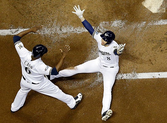 Ryan Braun celebrates with Brewers teammate Lorenzo Cain after scoring during the first inning of Friday night's Game 6 of the National League Championship Series against the Dodgers in Milwaukee.
