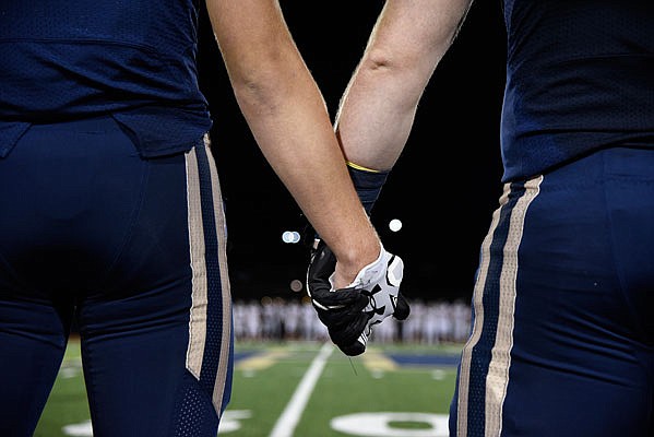 Helias team captains prepare to walk to the center of the field for the coin toss prior to the start of Friday night's game against De Smet at Ray Hentges Stadium.