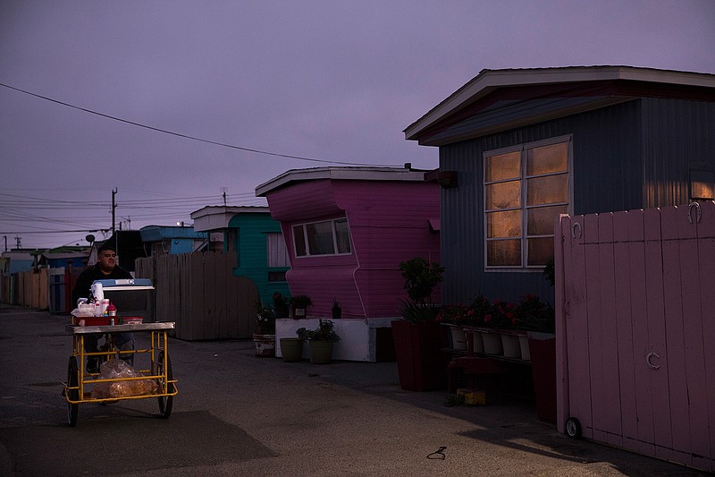 In this Monday, Sept. 3, 2018, photo, a food vendor passes through a mobile home park, where the majority of tenants are farm workers, in Salinas, Calif. Few cities exemplify California's housing crisis better than Salinas, an hour's drive from Silicon Valley and surrounded by farm fields. It's one of America's most unaffordable places to live, and many residents believe politicians lack a grip on the reality of the region's housing crisis. (AP Photo/Jae C. Hong)