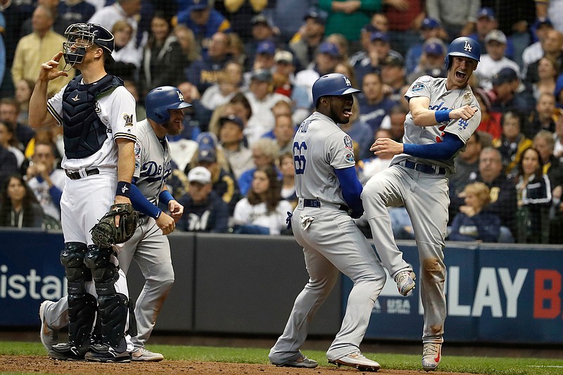 Los Angeles Dodgers' Yasiel Puig (66) celebrates with Cody Bellinger (35) and Max Muncy (13) after hitting a three-run home run during the sixth inning of Game 7 of the National League Championship Series baseball game against the Milwaukee Brewers Saturday, Oct. 20, 2018, in Milwaukee. (AP Photo/Jeff Roberson)
