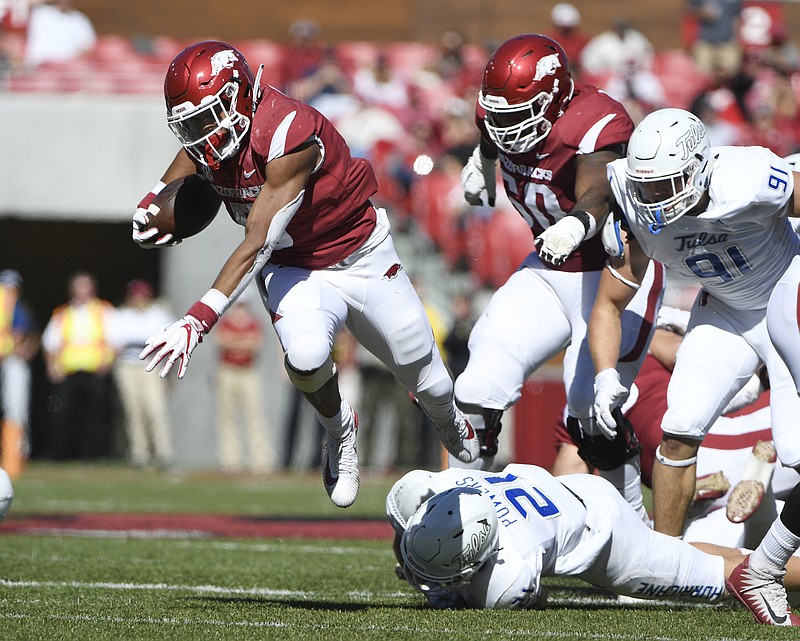 Arkansas running back Rakeem Boyd, top, gets past Tulsa defender Bryson Powers as he runs the ball in the first half of an NCAA college football game Saturday, Oct. 20, 2018, in Fayetteville, Ark. (AP Photo/Michael Woods)