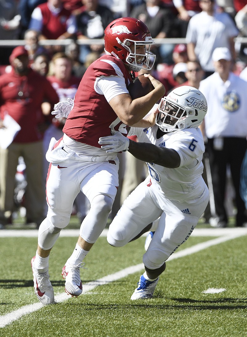 Arkansas quarterback Connor Noland tries to shake Tulsa defender Cristian Williams as he runs for a gain in the second half of an NCAA college football game Saturday, Oct. 20, 2018, in Fayetteville, Ark. (AP Photo/Michael Woods)