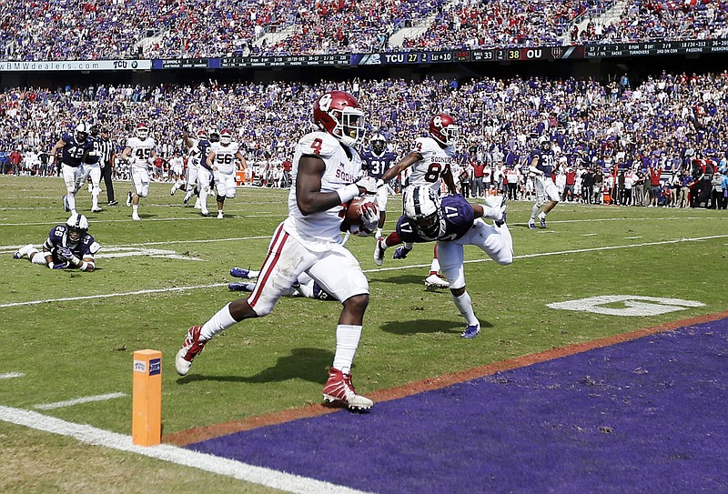 Oklahoma running back Trey Sermon (4) scores a touchdown during the second half of an NCAA college football game against TCU, Saturday, Oct. 20, 2018, in Fort Worth, Texas. Oklahoma won 52-27. (AP Photo/Brandon Wade)