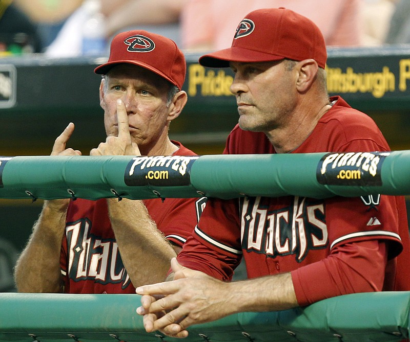 In this June 8, 2011 file photo, Arizona Diamondbacks bench coach Alan Trammell, left, gives signals standing next to manager Kirk Gibson during the fifth inning of a baseball game against the Pittsburgh Pirates in Pittsburgh. Stealing signs is as much a part of baseball tradition as stealing bases, but the technology available now could open a whole new frontier of competitive sleuthing. (AP Photo/Gene J. Puskar, File)