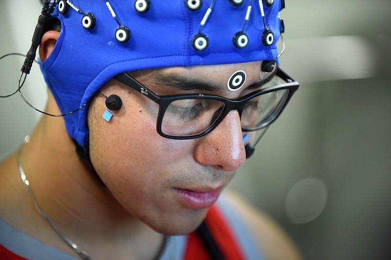 In this Sept. 21, 2018, photo, Jack Rodriguez, a student at Texas State University and has been a stutterer all of his life participates in a study at UTSA that uses electrodes on his head to pick up signals to graph what his brain is doing when he is speaking fluently and not in Texas. (Billy Calzada/The San Antonio Express-News via AP)