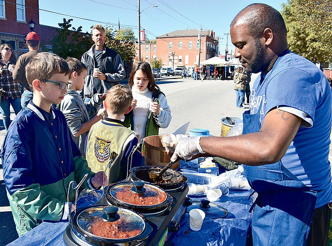 At right, Jerry Morgan of The Blue Skillet dishes up some chili Sunday for Alexzander Gage, 10, Jefferson City, at the first Steve Smart Memorial Chili Cook-off.