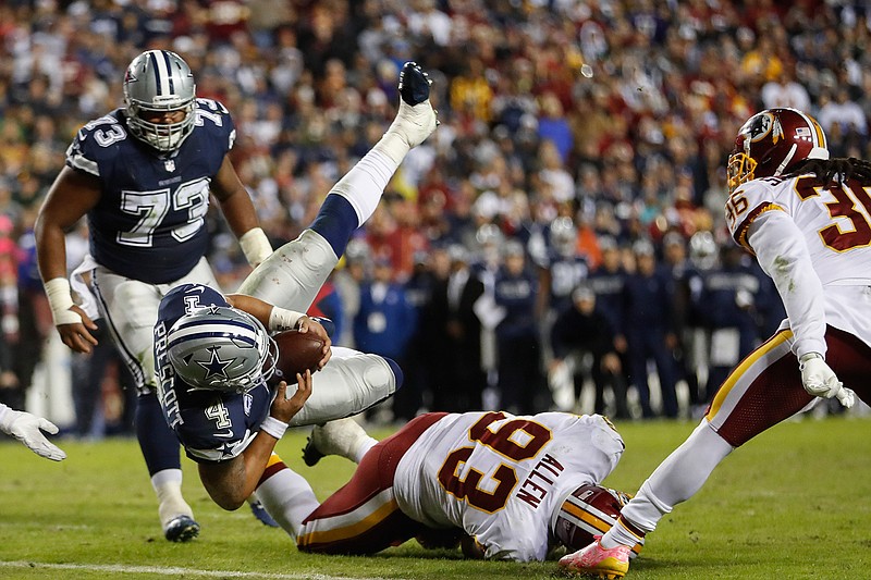 Dallas Cowboys quarterback Dak Prescott (4) dives over Washington Redskins defensive end Jonathan Allen (93) for a touchdown Sunday in Landover, Md. 