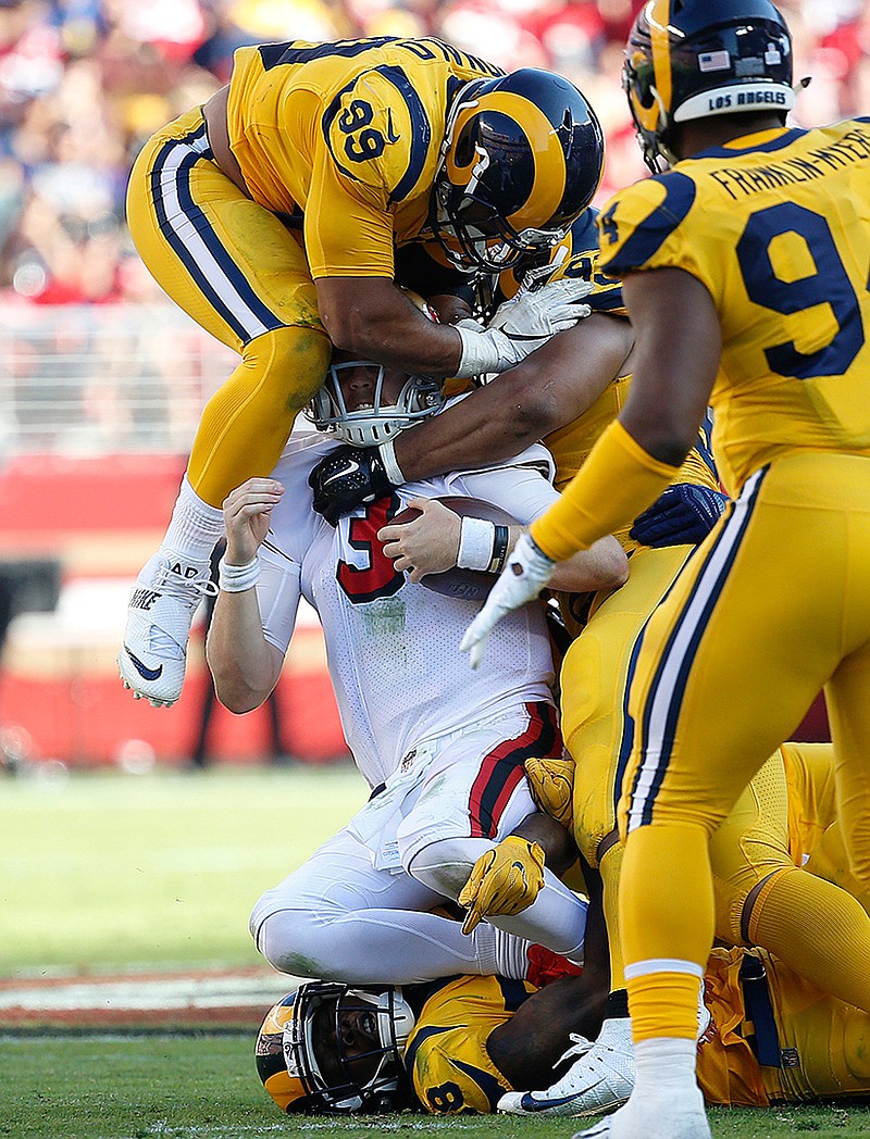  San Francisco 49ers quarterback C.J. Beathard (3) is tackled by Los Angeles Rams defensive tackle Aaron Donald, top, Cory Littleton, bottom, and Ndamukong Suh, second from right, on Sunday in Santa Clara, Calif. 
