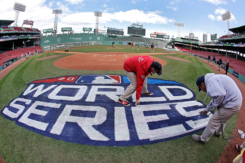 Grounds crew members paint the World Series logo behind home plate on Sunday at Fenway Park in Boston as they prepare for Game 1 of the World Series between the Boston Red Sox and the Los Angeles Dodgers scheduled for Tuesday. 
