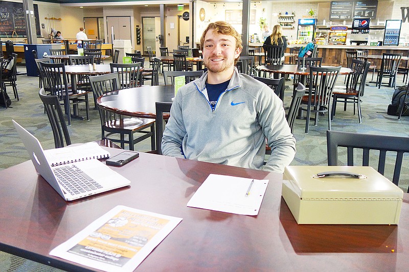 Matt Hagen, a junior and member of Westminster College's Pre-Healthcare Professionals' Association, takes a shift in the Hunter Activity Center signing people up for the Miles for Maasai 5K.