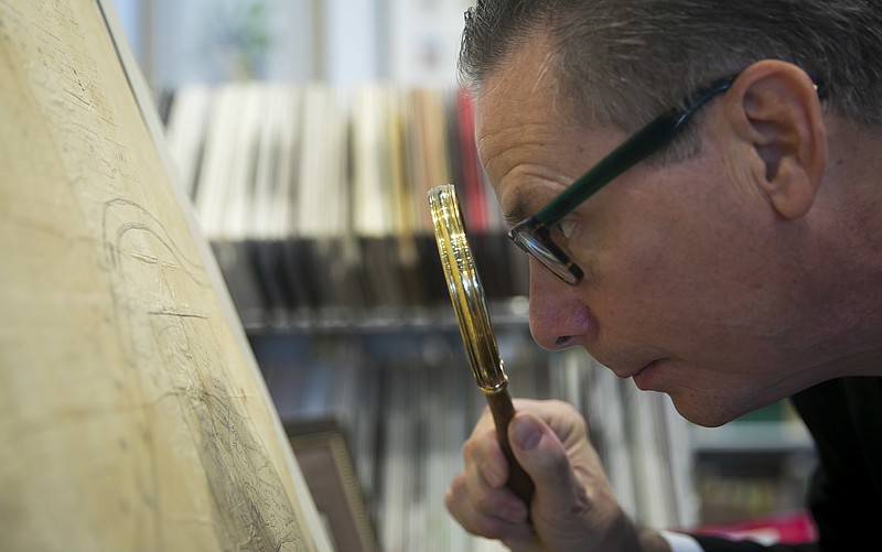 In this Thursday, Oct. 18, 2018 photo, Ed Grusnis, owner of the Antiquarium in River Oaks, studies one of the original maps of Houston, created by the Allen brothers, in his store in Houston. (Annie Mulligan/Houston Chronicle via AP)