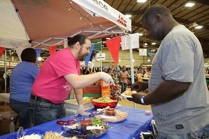 Debo Ricks is served a tasty treat Tuesday from U.S. Pizza Co. at the annual Taste of Texarkana. About 40 vendors were on hand to help raise money for the Harvest Regional Food Bank.