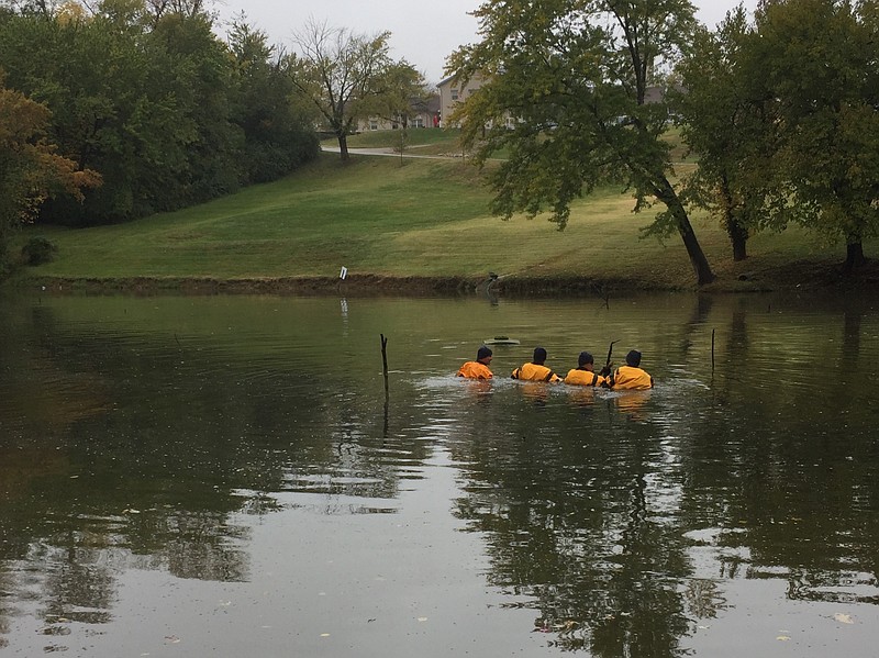 Missouri Highway Patrol Dive Team members comb the pond at Hyder Apartments on Friday, Oct. 26, 2018, in Jefferson City as part of the search for missing 4-year-old boy Darnell Gray.