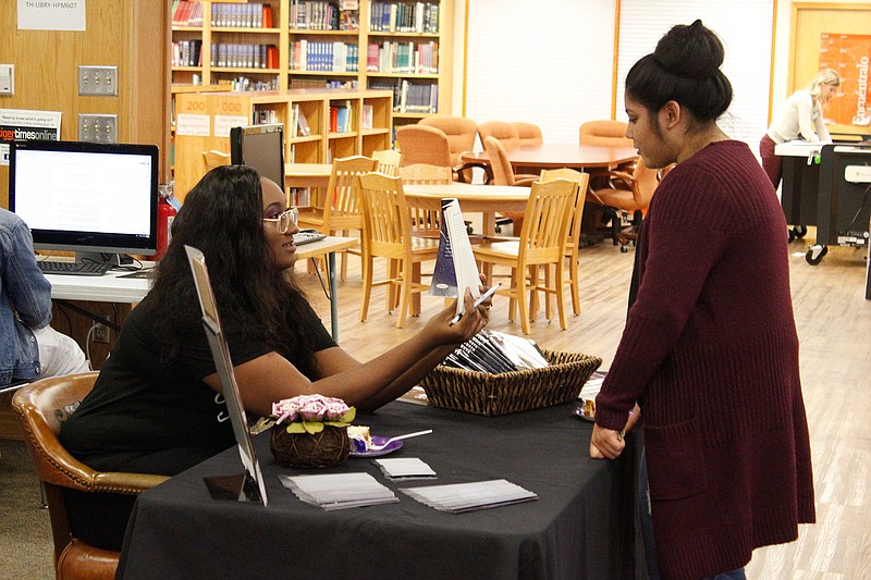 Texas High senior and author Trinitee Noel holds a copy of her book, "Worth," while Ana Zepeda reads the pledge contained within the tome's pages. The fictional work is the 17 year old's first book.
