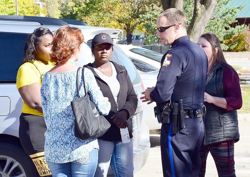 The mother of missing 4-year-old Darnell Gray, center, speaks to a Jefferson City police officer Monday in Washington Park. Darnell Gray was last was seen Wednesday night in Jefferson City.