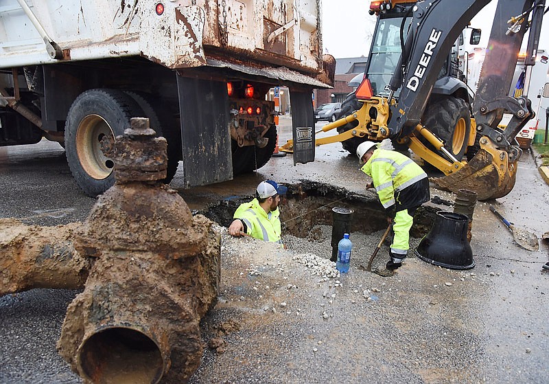 After removing the old valve, in foreground, employees of Missouri American Water worked Thursday, March 9, 2017, to install a replacement valve on the water line at the intersection of East Capitol Avenue and Adams Street. (News Tribune file photo)