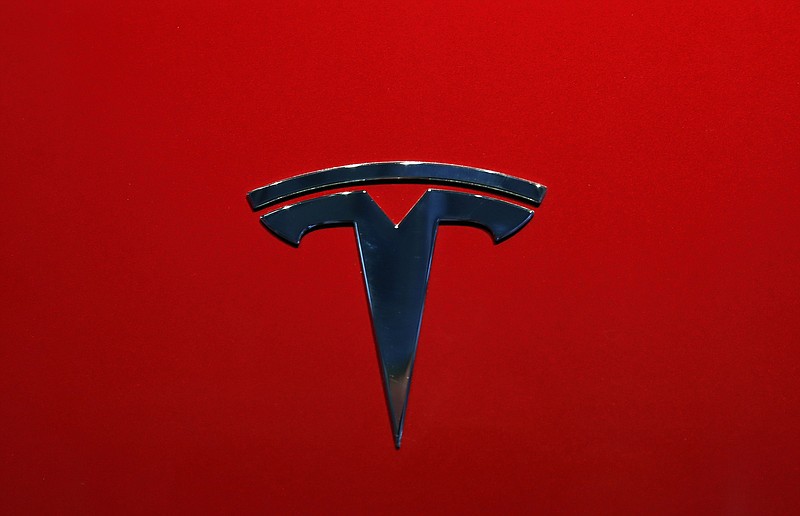 FILE- This Oct. 3, 2018, file photo shows the logo of Tesla Model 3 at the Auto show in Paris. U.S. securities investigators have subpoenaed information from Tesla about production forecasts for the Model 3 electric car that were made last year, the company acknowledged in a regulatory filing Friday, Nov. 2. The disclosure in Tesla’s quarterly financial report also says the Securities and Exchange Commission subpoena covered other public statements made about Model 3 production. The filing also says Tesla is cooperating with a Justice Department request for information about production. (AP Photo/Christophe Ena, File)