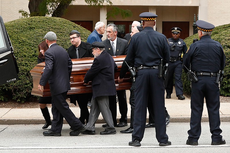 Pittsburgh police stand guard as pallbearers carry the casket of Irving Younger, 69, from Congregation Rodef Shalom after his funeral on Wednesday, Oct. 31, 2018, in Pittsburgh. Younger was one of the eleven victims killed in the deadly shooting at a synagogue in Pittsburgh's Squirrel Hill neighborhood on Saturday. (AP Photo/Keith Srakocic)