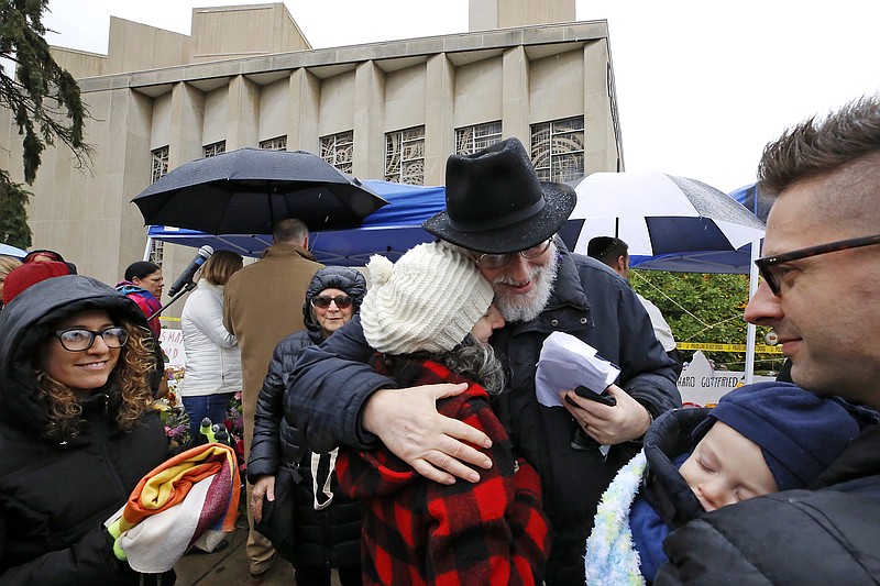 Rabbi Chuck Diamond, center, a former Rabbi at the Tree of Life Synagogue, hugs a woman after leading a Shabbat service outside the Tree of Life Synagogue, Saturday, Nov. 3, 2018 in Pittsburgh. Last Saturday, 11 people were killed and six wounded when their worship was interrupted by a gunman's bullets. (AP Photo/Gene J. Puskar)